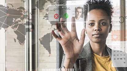Person vor digitaler Oberfläche mit Weltkarte und Anrufanzeige