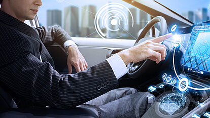 Eine Frau bedient das Cockpit in einem Auto